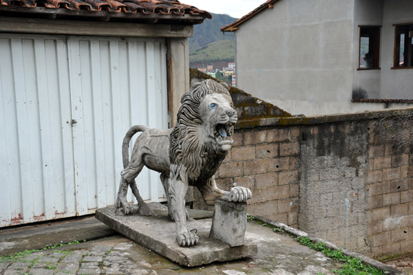 Sculpture of a rather thin lion in front of a garage in Mariana