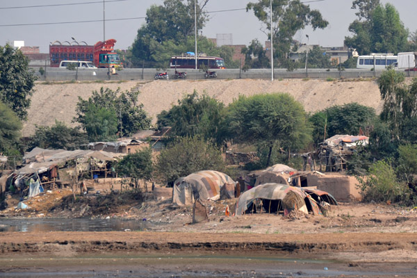 Camp with what looks like nomad's tents along the river, Lahore