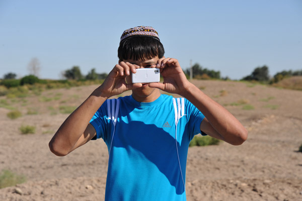 Turkmenistan boy taking photos of the foreign tourist