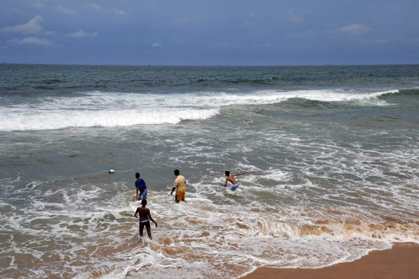 Not idea for swimming, some boys wade into the sea - Galle Face