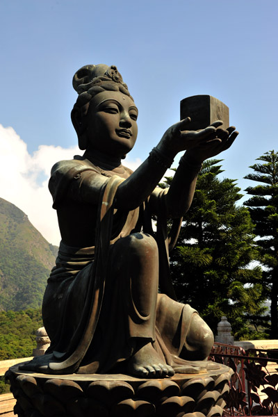 Numerous bronze statues of offerings surround the Buddha