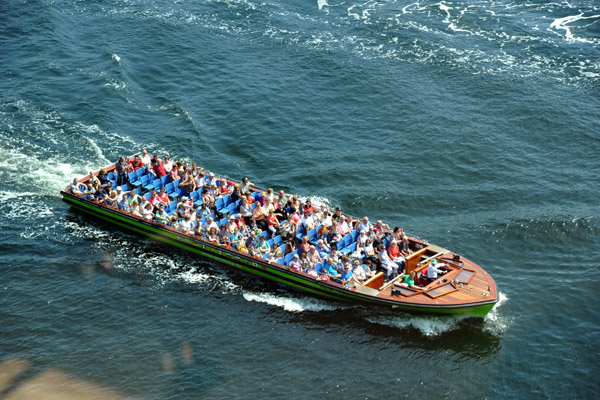A canal tour boat passes the Copenhagen Marriott