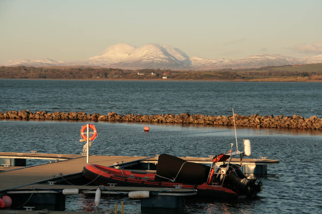 Sunset at Bowmore harbour with the Paps of Jura in the distance