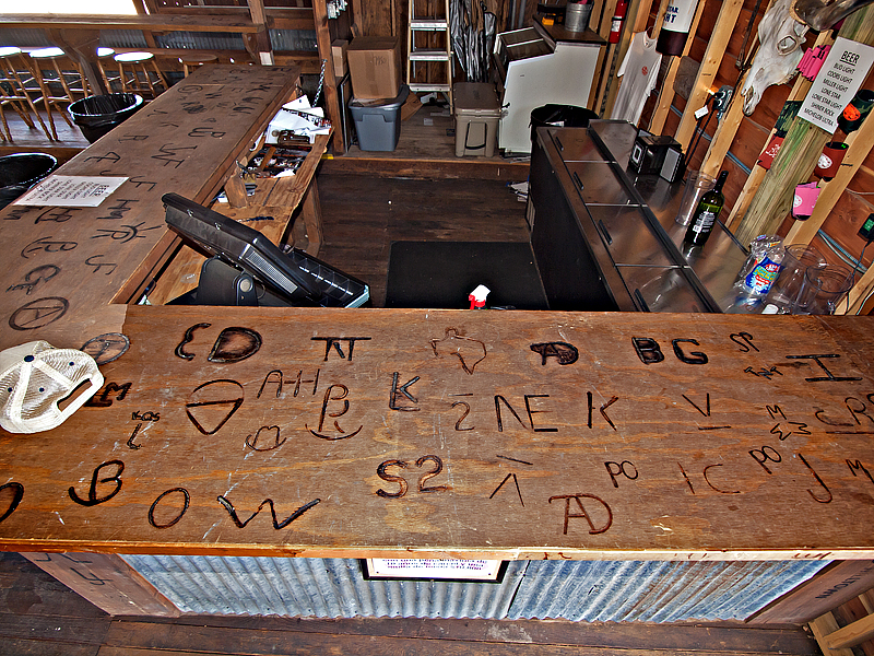 A close-up of the bar showing the ranchers brands burned into the bar on Branding  night. 