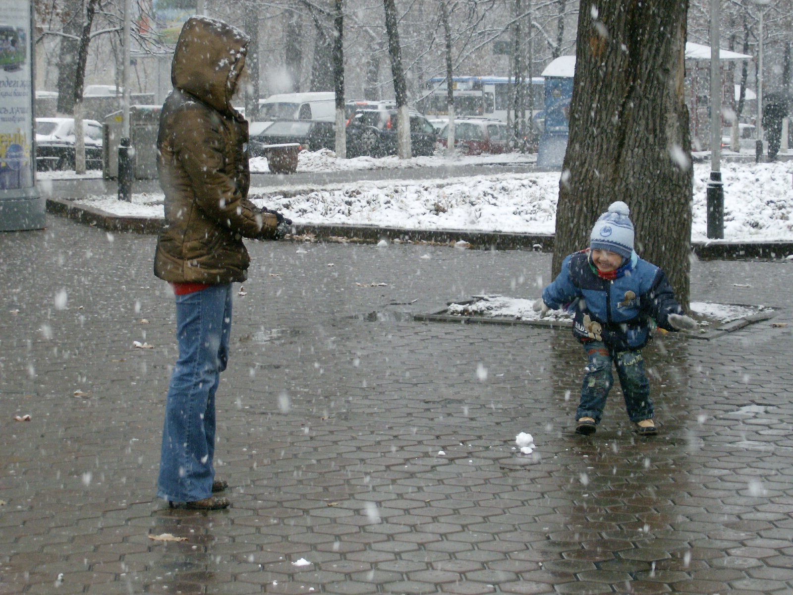Mother and child play snowball in the first snow on Dostyk. His first year to be old enough?