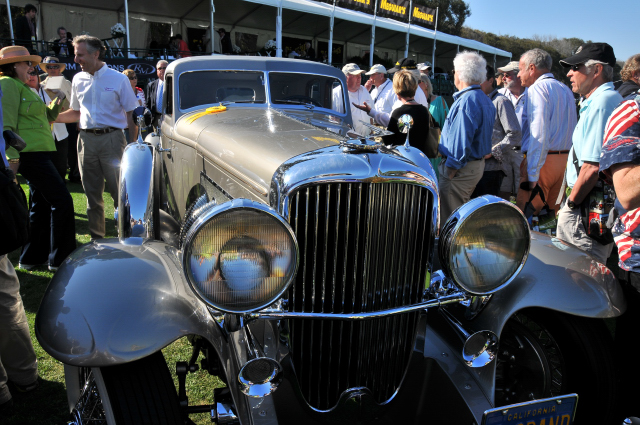 Helen Nethercutt talks to fellow car collector Bruce Meyer, rear left, behind 1933 Duesenberg SJ Arlington Torpedo Sedan