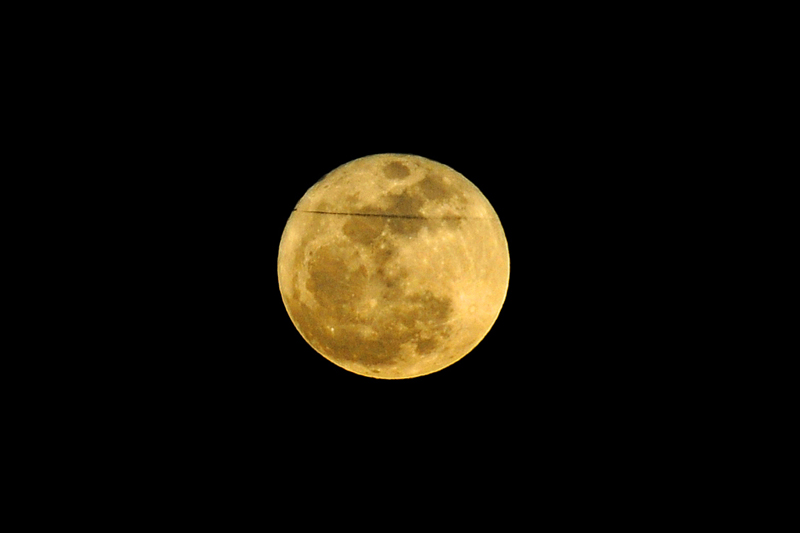 Jet contrail passing over Supermoon over the Chesepake Bay from Solomon's Island, Md