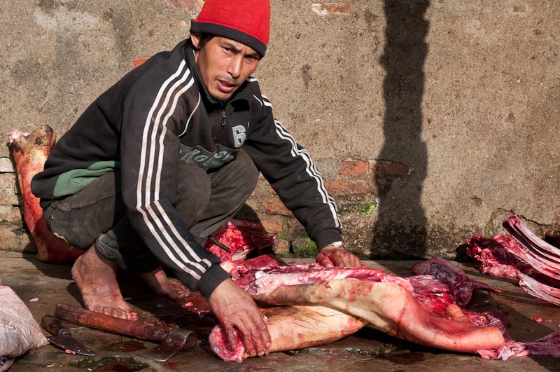 Butcher at work in the back streets