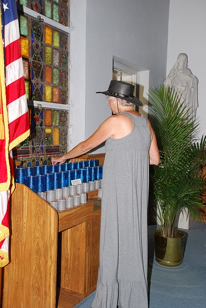 SARA LIGHTS ANOTHER VIGIL CANDLE AT ST ROSE OF LIMA CHURCH