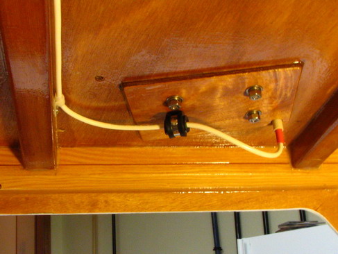 VHF antenna entry cuddy port corner; drip loop and chafe protection (black fuel hose).