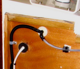 VHF and allaround power, rear of cuddy bulkhead; chafe protection is household TV cable pass-throughs.