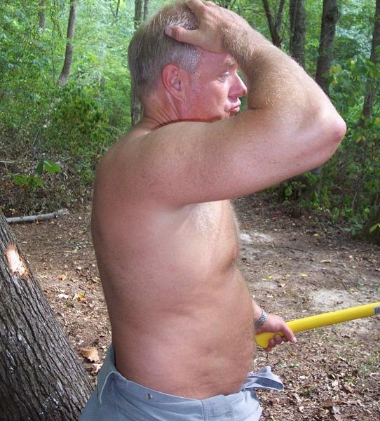 big blond older hunky man cutting wood.jpg