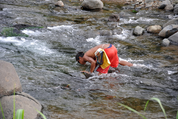 Villager using goggles to search the river
