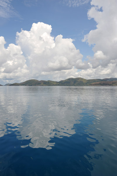 Cloud reflections on the glassy surface of Coron Bay