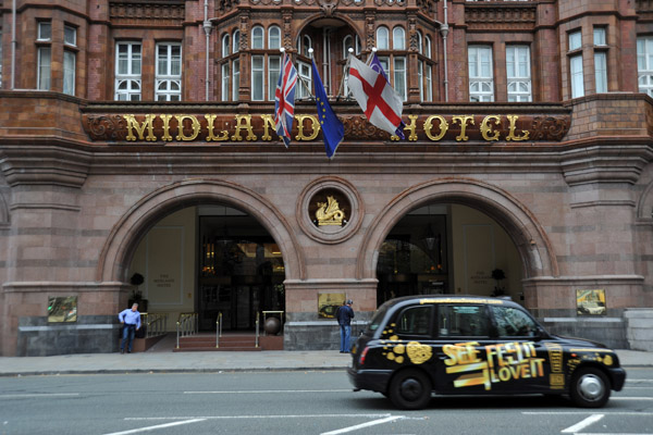 A black British taxi on Peter Street in front of Manchester's Midland Hotel