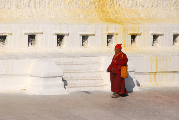 Tibetan monk passing the 108 niches on the stupa