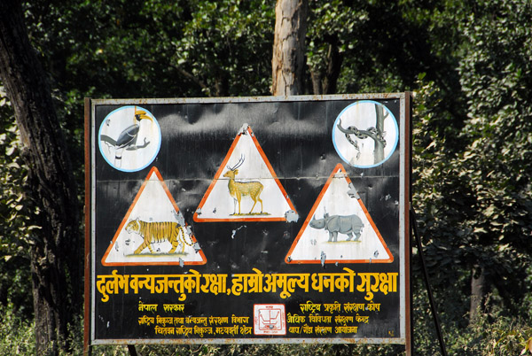 Chitwan buffer zone - warning signs for Tiger, Rhino, Python, Chital (spotted deer) and Crested Hornbill