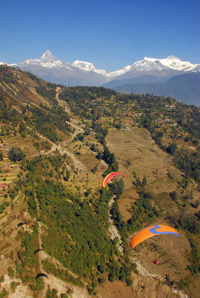 Looking down at two other paragliders