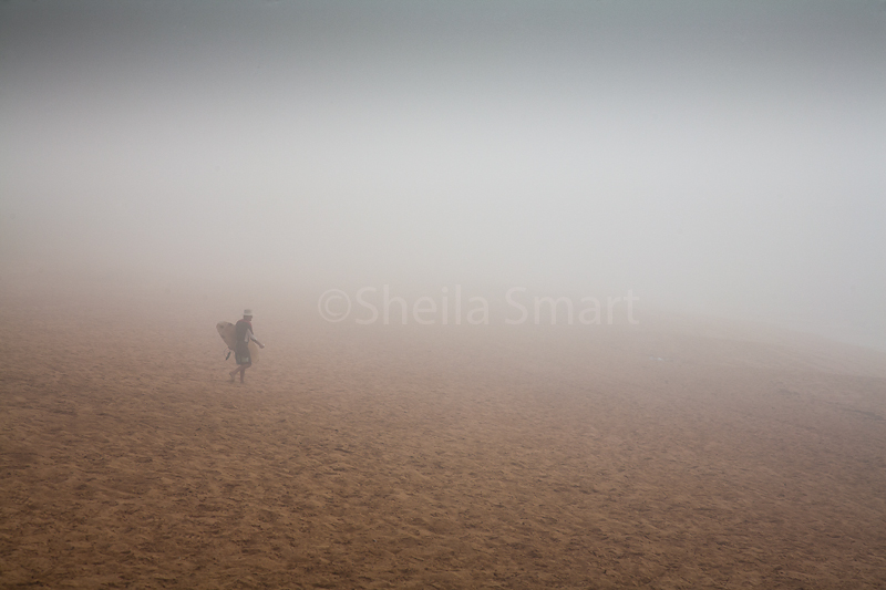 Surfer in rolling sea mist at Avalon Beach