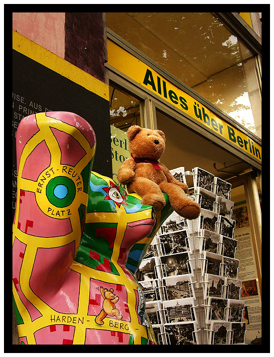 Frimpong sitting on a Buddy bear in front of a souvenir shop