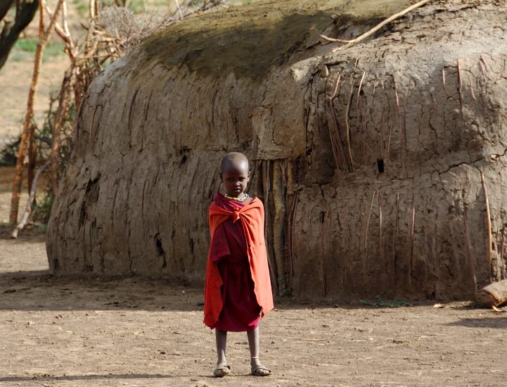 Masai child in front of hut