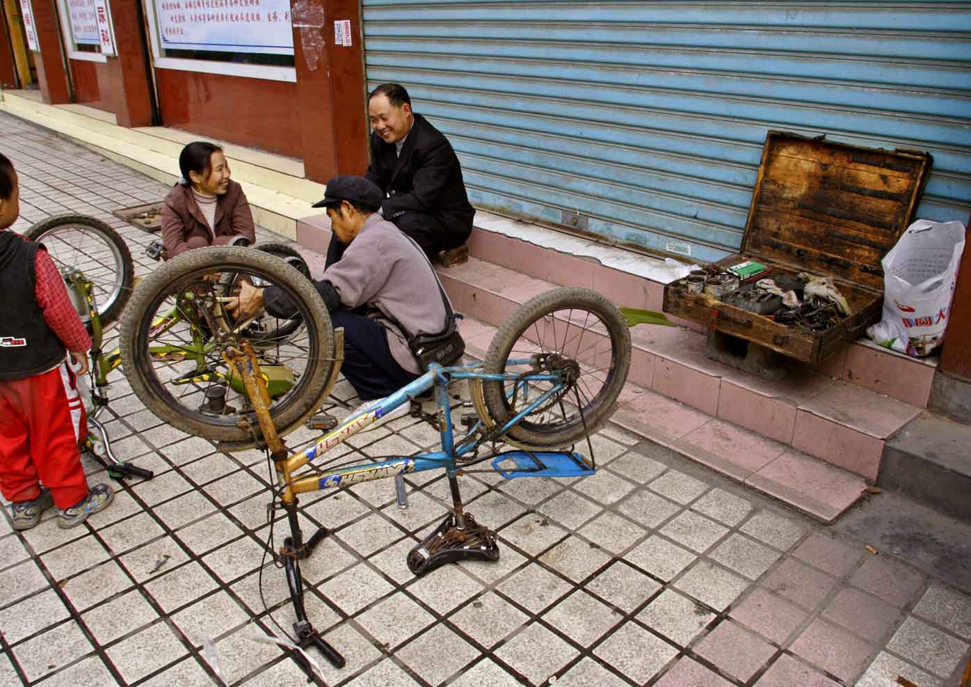 Sidewalk bicycle repairman.  Jishou City, Hunan Province, China