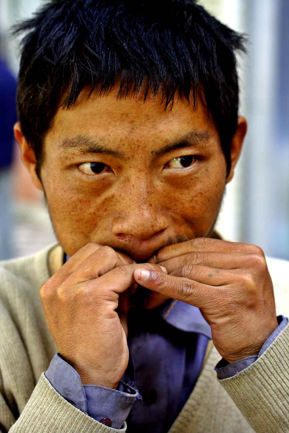 Dai man using a leaf as traditional instrument for music Kumming, China.