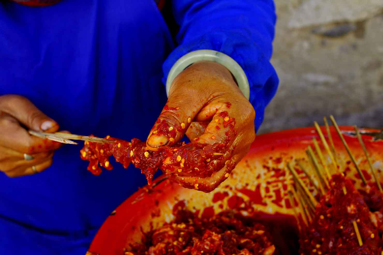 Preparring meat with hot peppers for cooking. Dali, China.