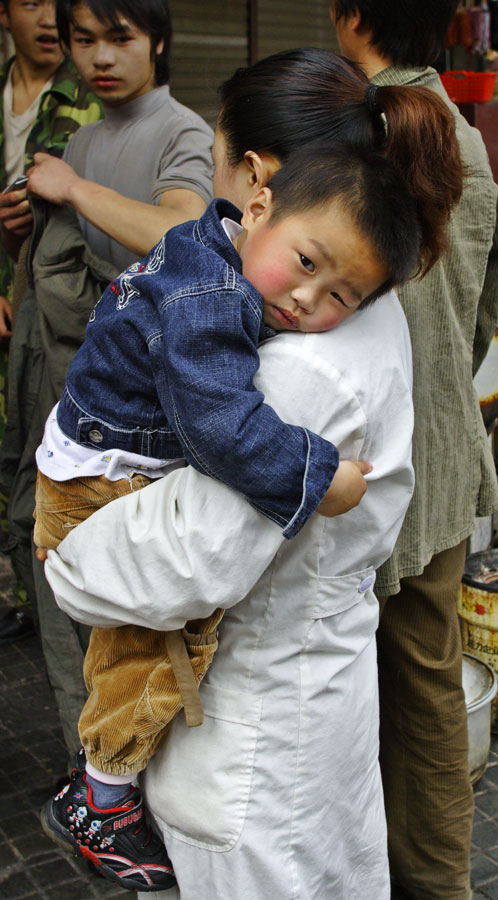 Child being held by mother. Jishou City, China
