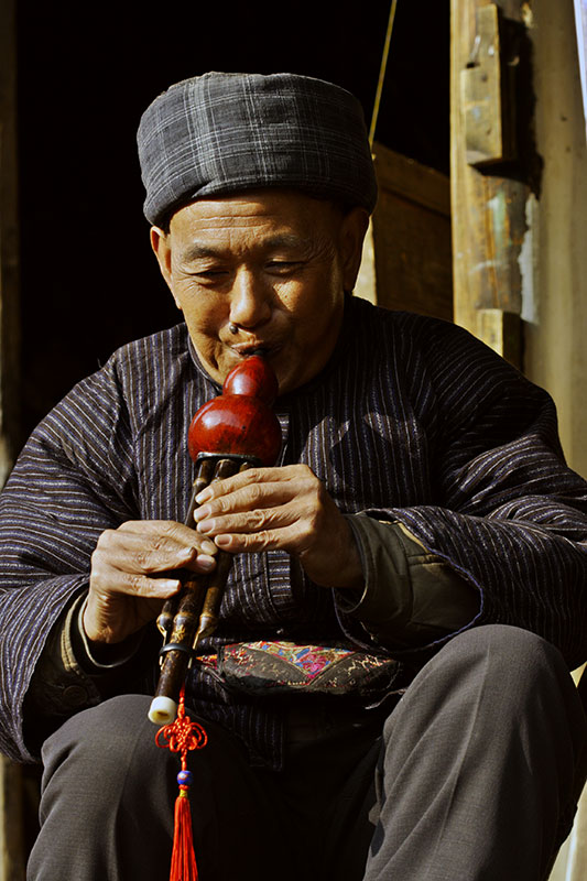 A master playing a Hmong traditional gourd instrument.