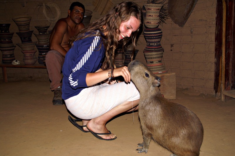 Kristine having her finger sucked from a tame capybara