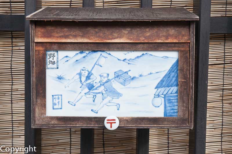 An idiosyncratic mailbox evokes the postal runners of the Edo Period
