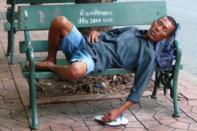 Sleeper oblivious of peak hour traffic rushing past beside him