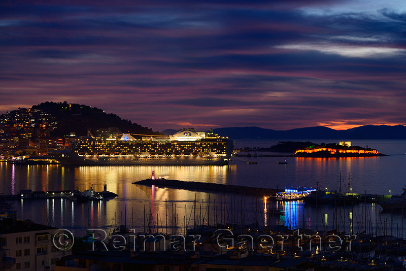 Kusadasi Turkey Harbour at twilight with Guvercin Adasi castle and cruise ship on the Aegean Sea