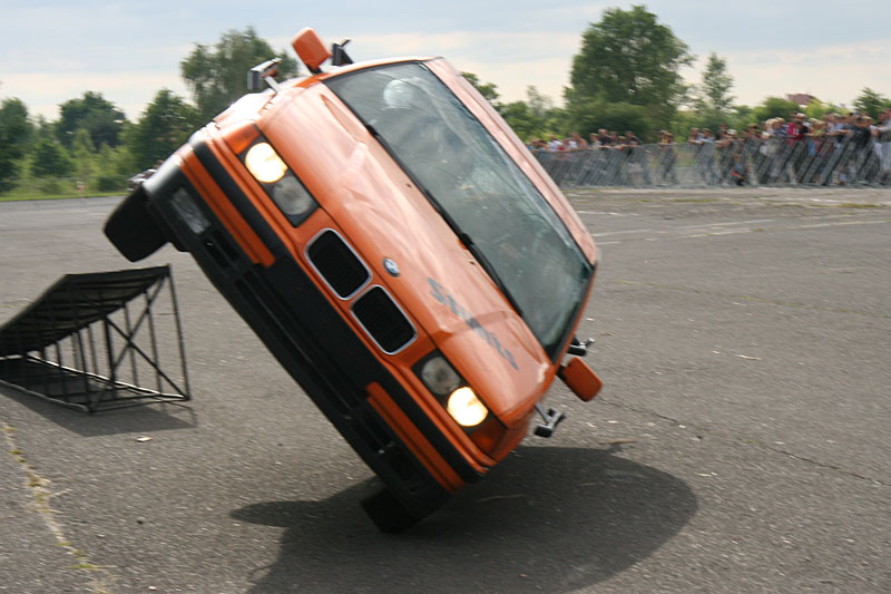 Girls inside stunts car on two wheels drive