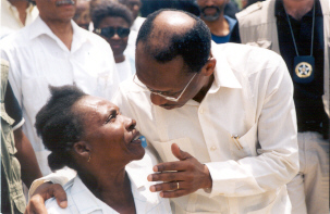 President Aristide speaks with woman in La Saline