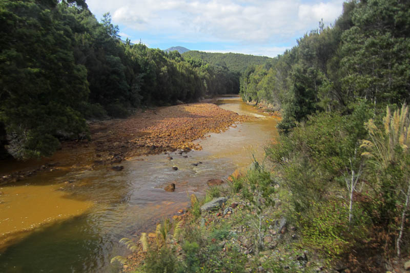 The King River stained with mining smelter waste