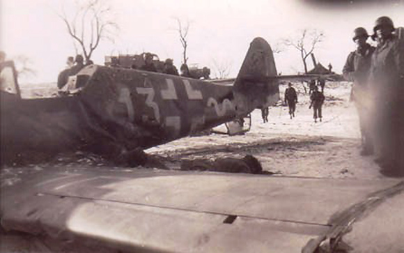 GIs take a look at the scene, the dead pilot still lies near the left wing.