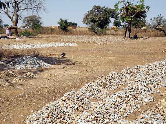 Stones from the former gold mine are cut into pieces and sold for house building, Laongo, Burkina Faso