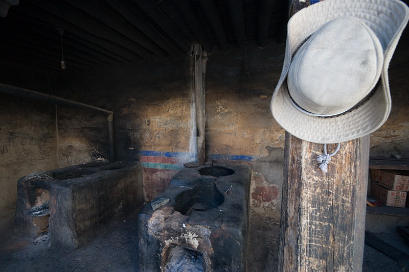 Tibetan cowboy hat hanging outside a kitchen.