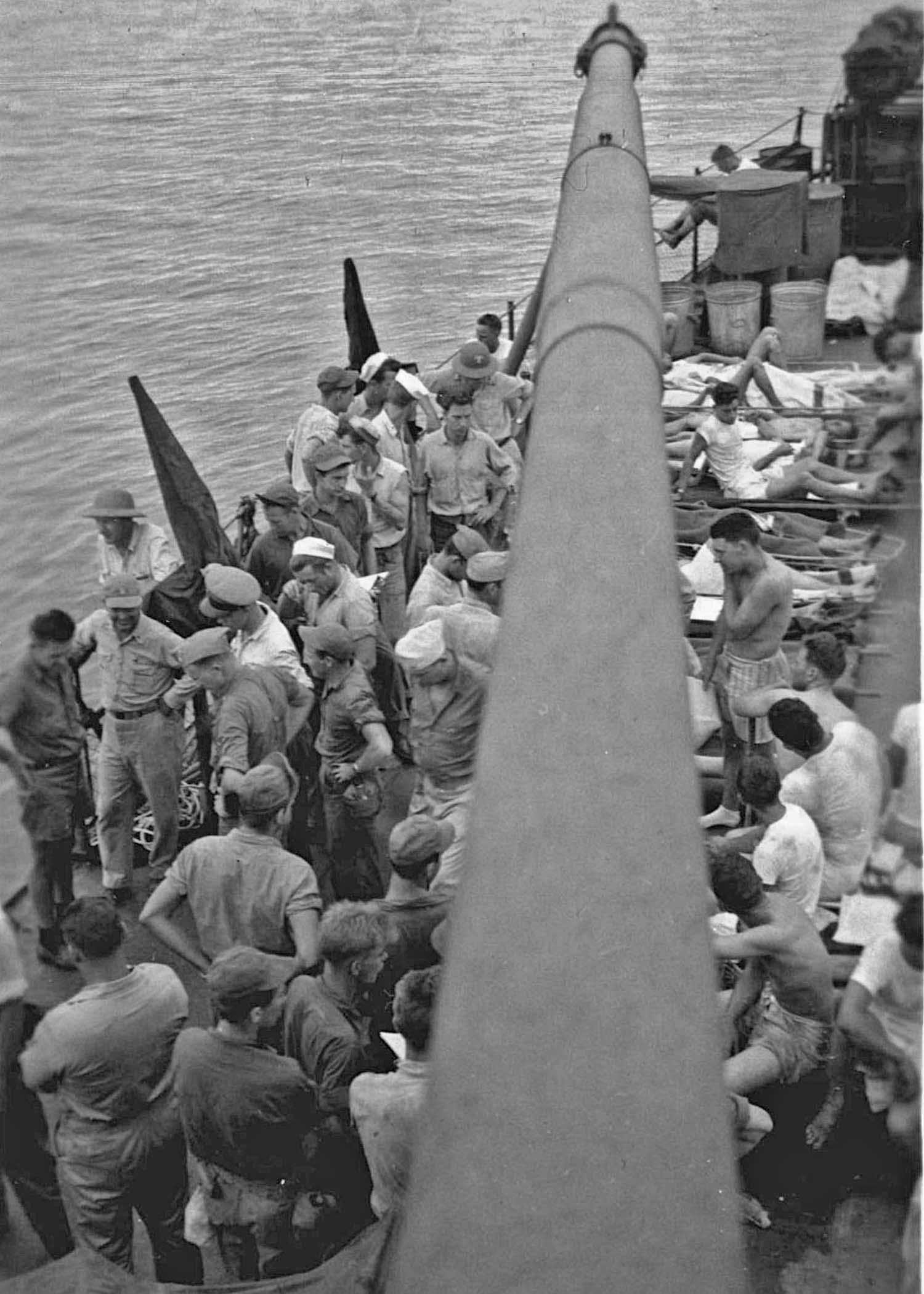 USS Indianapolis - Survivors on the deck  of the USS Bassett  - Sitting around long pole (8)
