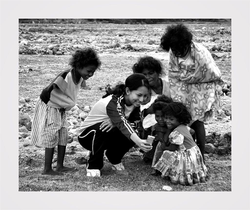 Pamapanga, Philippines. Cheap Thrills. One member of our group shows a digital picture to some of the locals