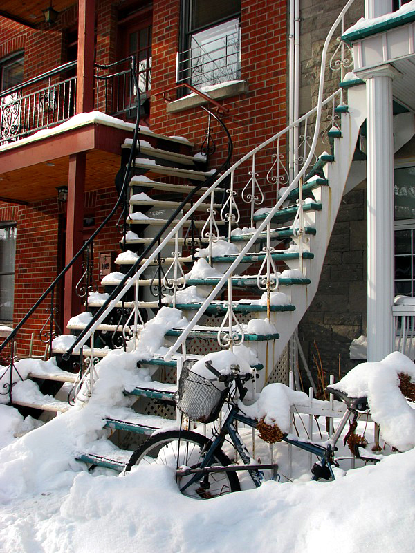 le vélo au panier percé devant les escaliers de Montréal