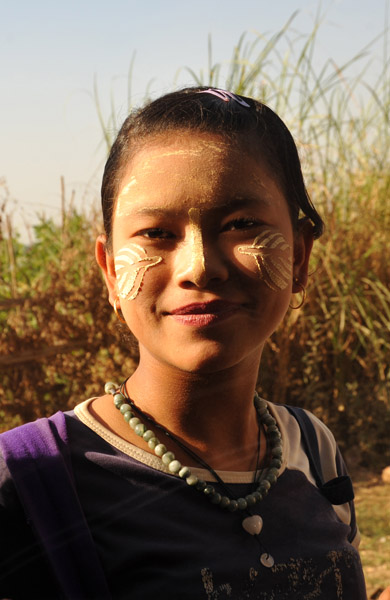 Burmese girl with face paint in the shape of leaves