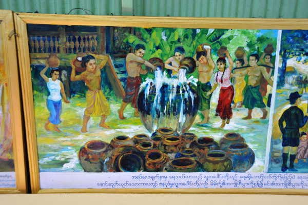 Villagers filling a large water vessel to overflowing