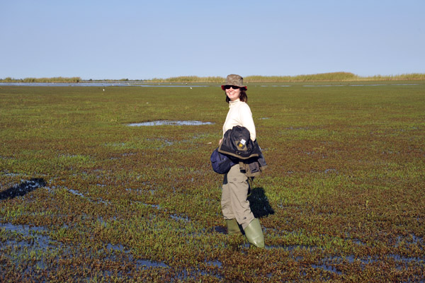 Anna hiking across the marshy ground towards the airstrip