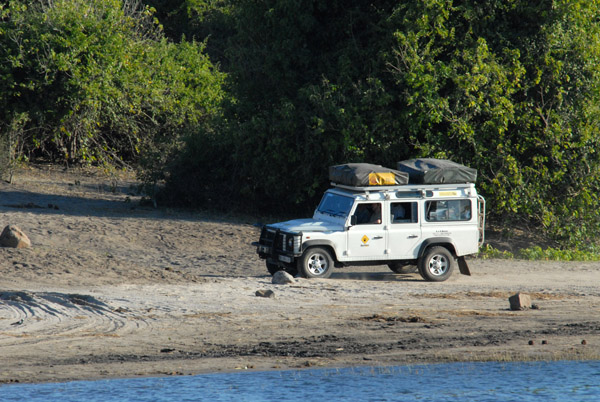 Land Rover of a mobile safari (Bushlore) driving the track along the Chobe River