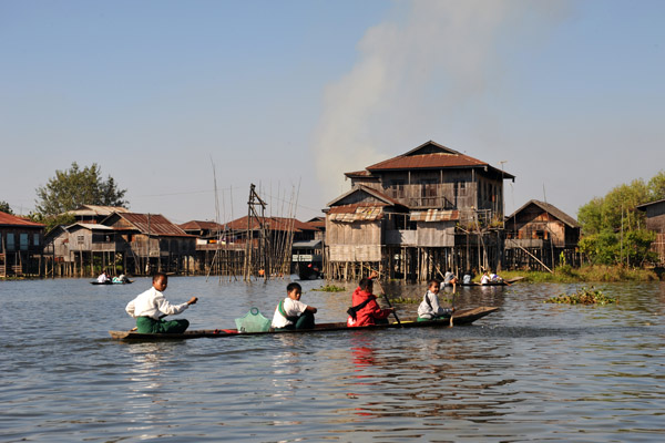 Another canoe with boys heading home from school