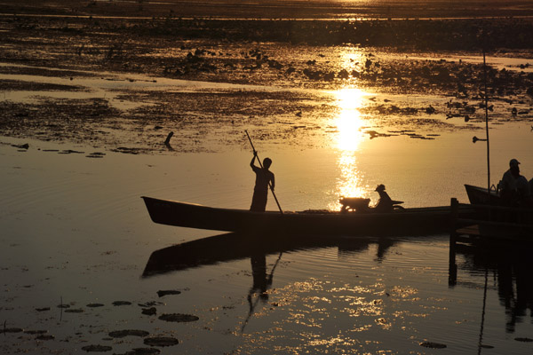 Silhouette of a long boat poler