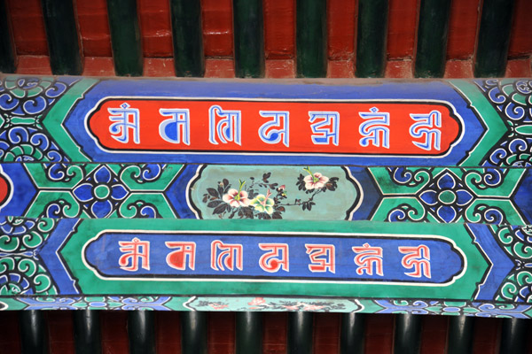 Painted support beam with what is probably sanskrit letters